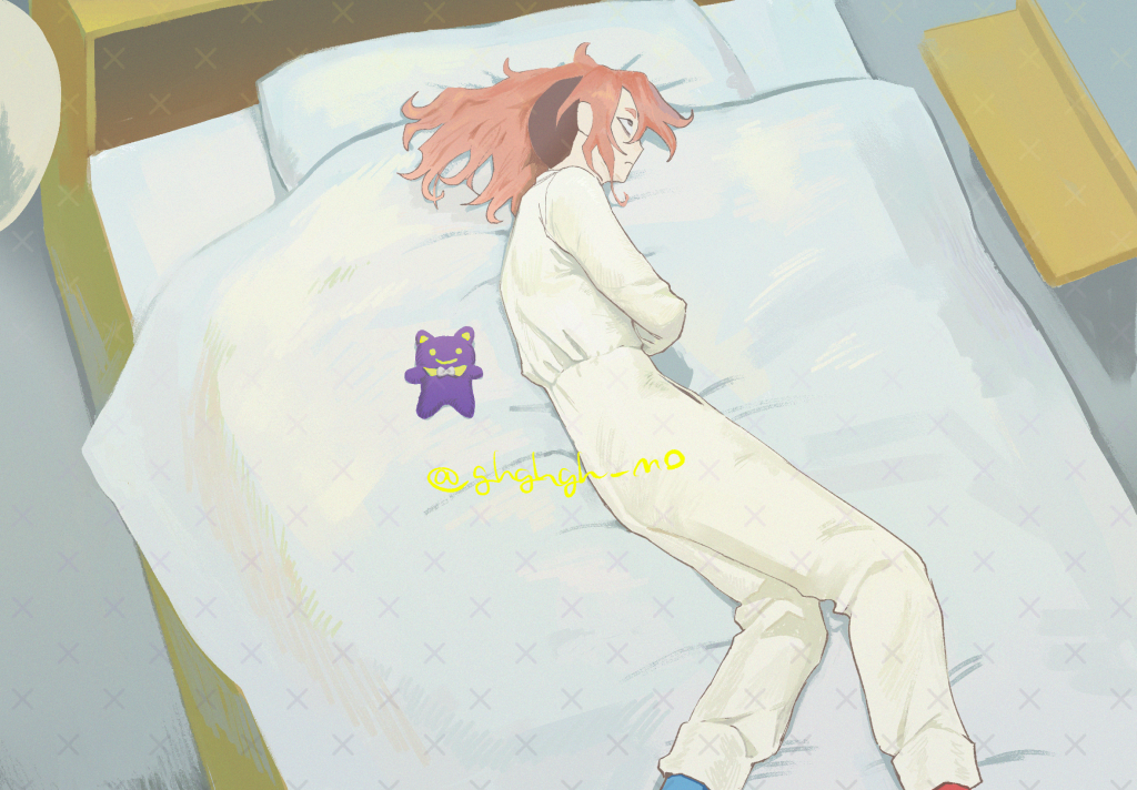 このサイトで店番と呼んでいる人物が、ベッドの上に寝転んでいる。傍に小さな紫色のクマのようなぬいぐるみが置かれている。